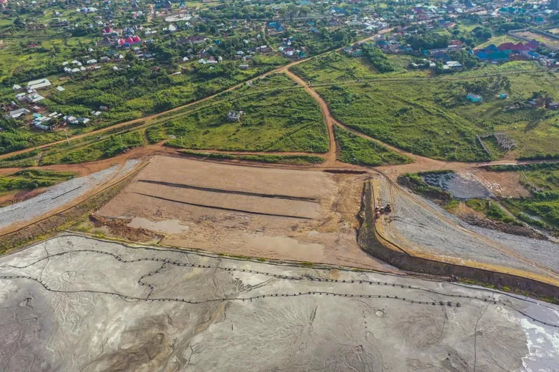 Earthworks beside green land at North Mara