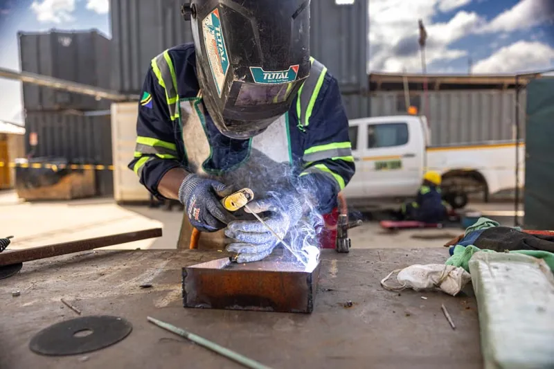 A Taifa welder in protective gear
